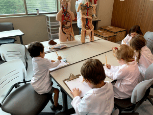 Young children in lab coats taking a science course