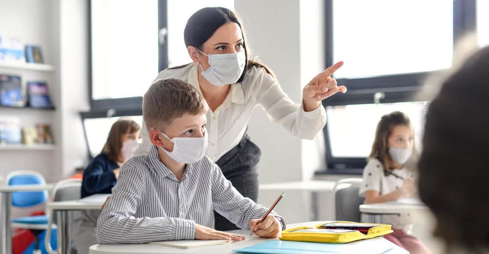 Student and Teacher in classroom wearing masks