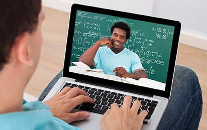 Mid adult man attending online math's lecture on laptop at home