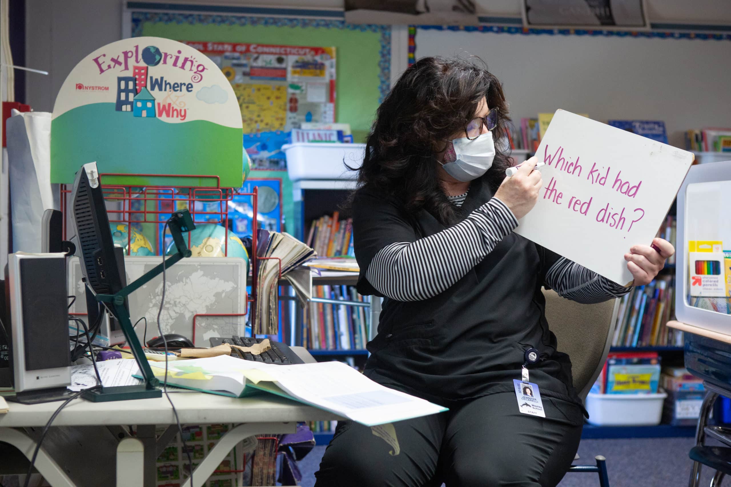 A second-grade teacher uses a white board to teach both her in-class and online students at Wesley Elementary School.