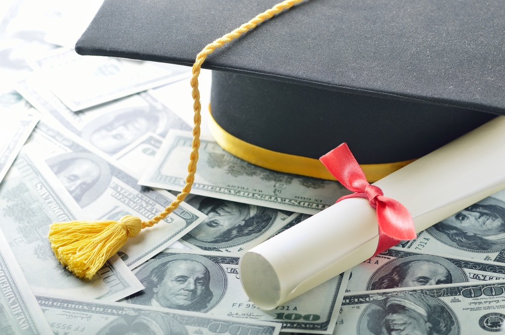 Graduation hat with diploma and money